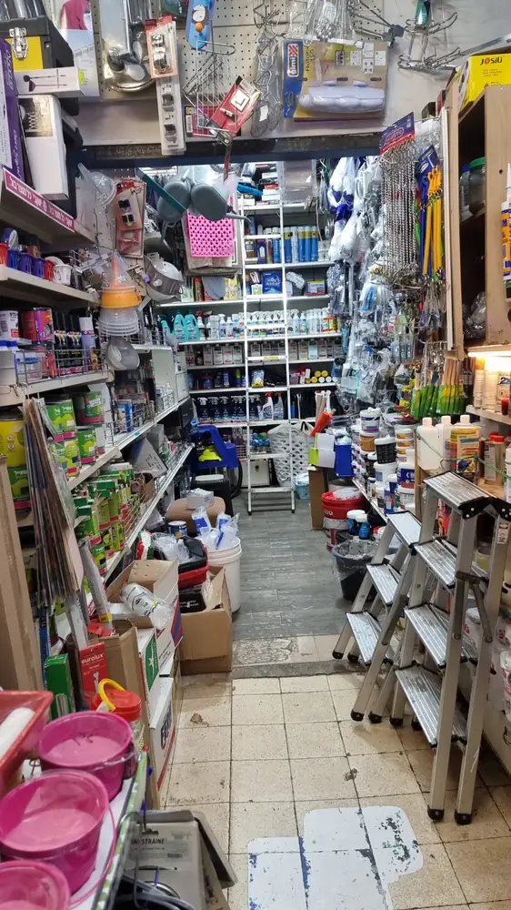 מדף בחנות עם פחיות צבע, מברשות וגלילים