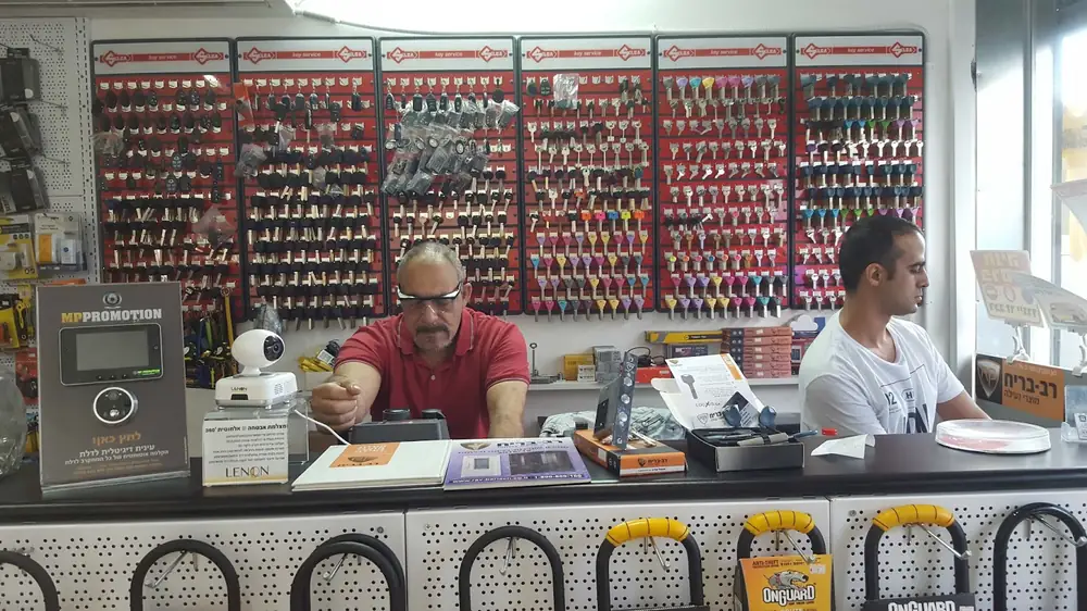 קיר מפתחות גולמיים בסניף, לצד שלט מוצרי נעילה של רב בריח על הדלפק